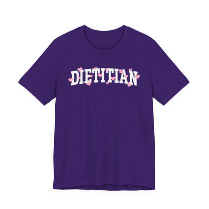 Purple tshirt with arched "DIETITIAN" text in white with pink hearts sprinkled throughout the letters