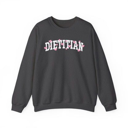 Charcoal sweatshirt with arched "DIETITIAN" text in white with pink hearts sprinkled throughout the letters.