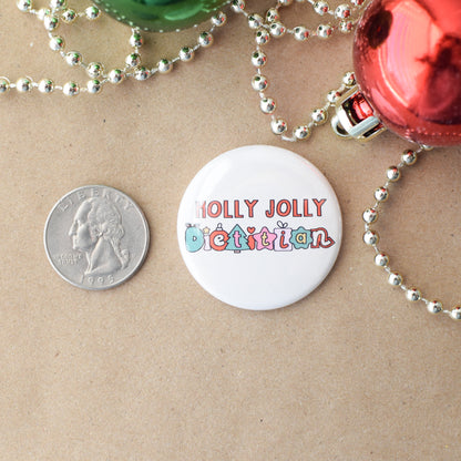 Button badge with 'Holly Jolly Dietitian' text on a beige background with Christmas decorations.