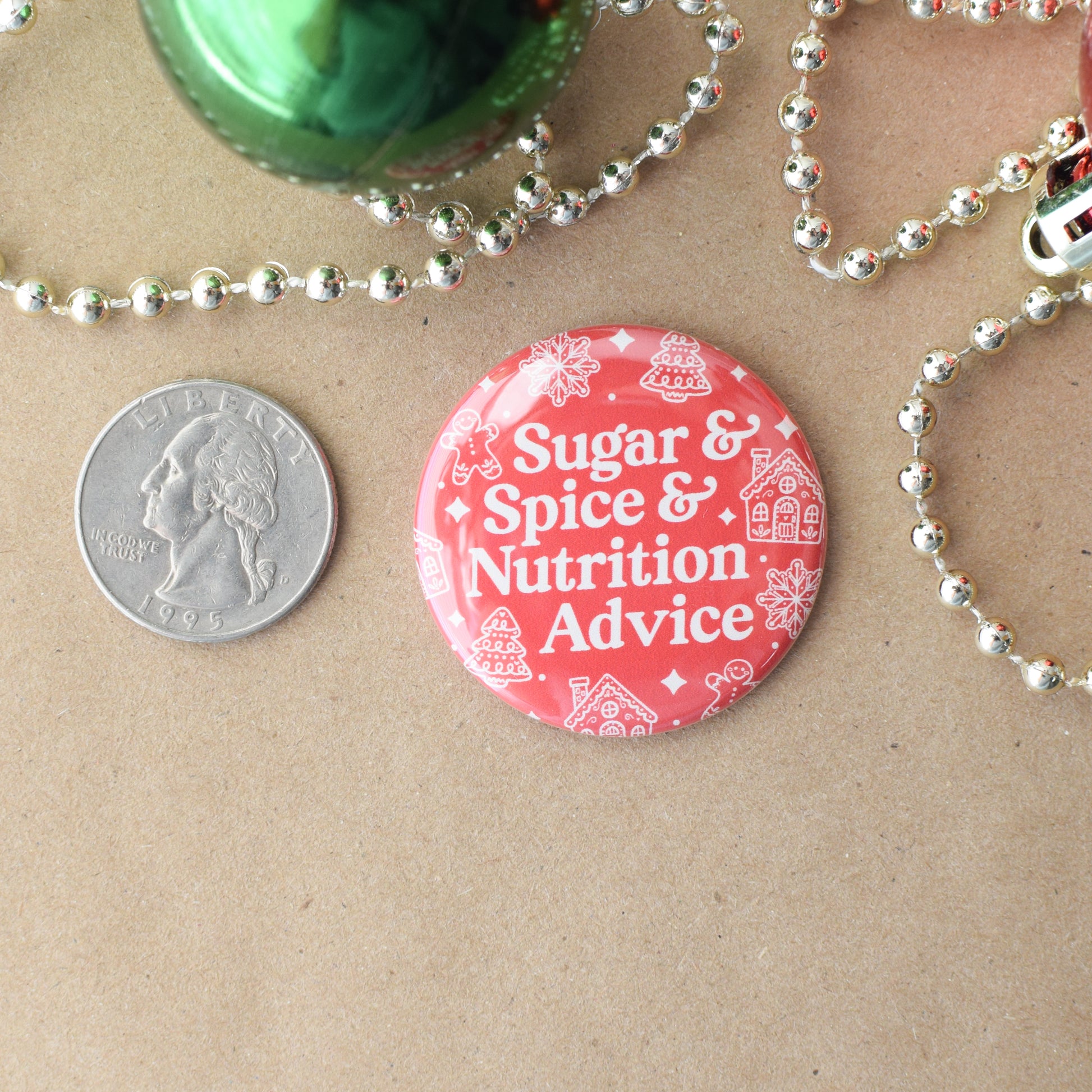 Red button with 'Sugar & Spice & Nutrition Advice' text on a brown surface with a coin for scale.