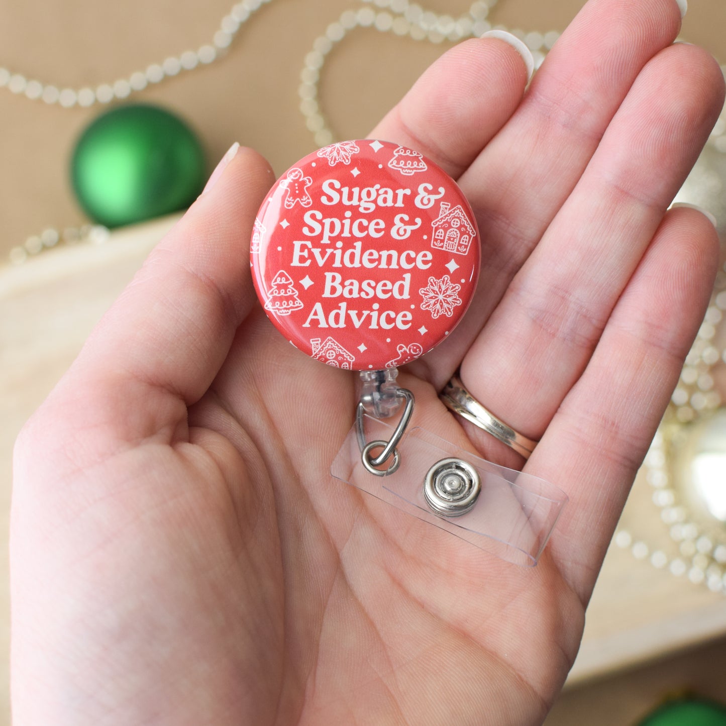 Red badge holder with 'Sugar & Spice & Evidence Based Advice' text held in a hand.