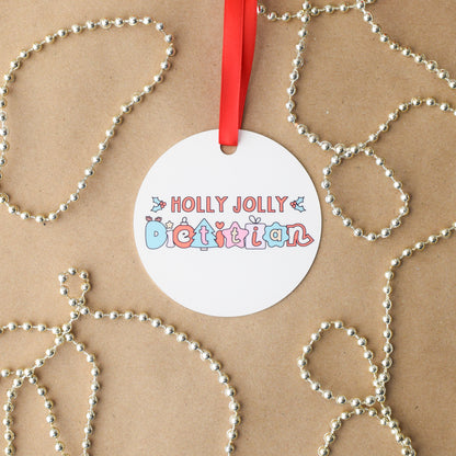 Round off-white ornament with 'Holly Jolly Dietitian' text on a brown background with decorative elements.