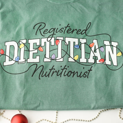 Close up of green tshirt with Registered Dietitian Nutrition text tangled in Christmas lights