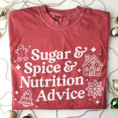 Red t-shirt with white text 'Sugar & Spice & Nutrition Advice' and white gingerbread cookie graphics on a decorative background