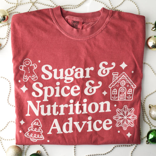 Red t-shirt with white text 'Sugar & Spice & Nutrition Advice' and white gingerbread cookie graphics on a decorative background