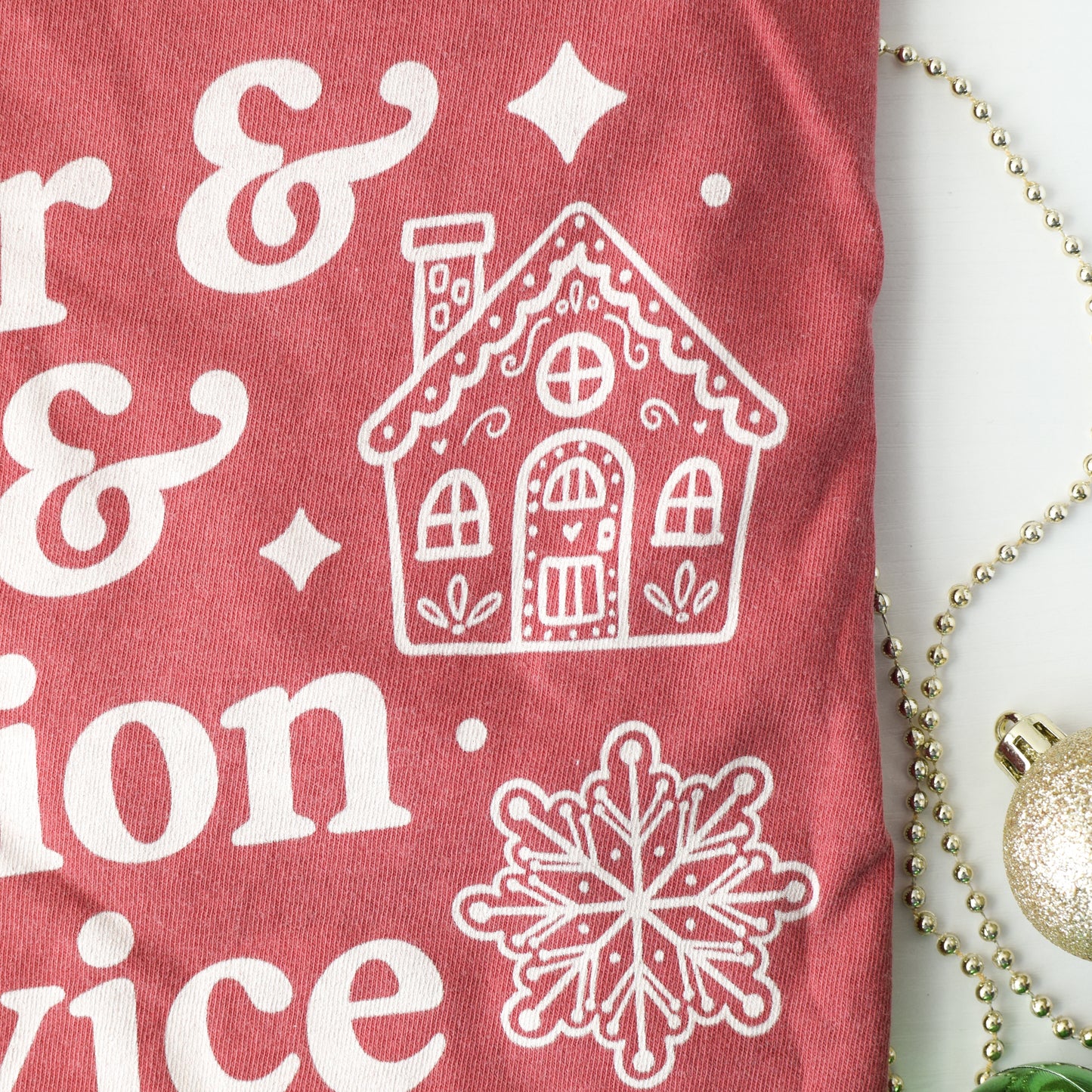 Close up of Red t-shirt with white gingerbread cookie graphics on a decorative background