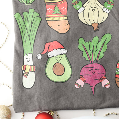 Close up of gray tshirt with cartoon avocado, beetroot, and leek wearing Christmas hats and scarves on a white background.