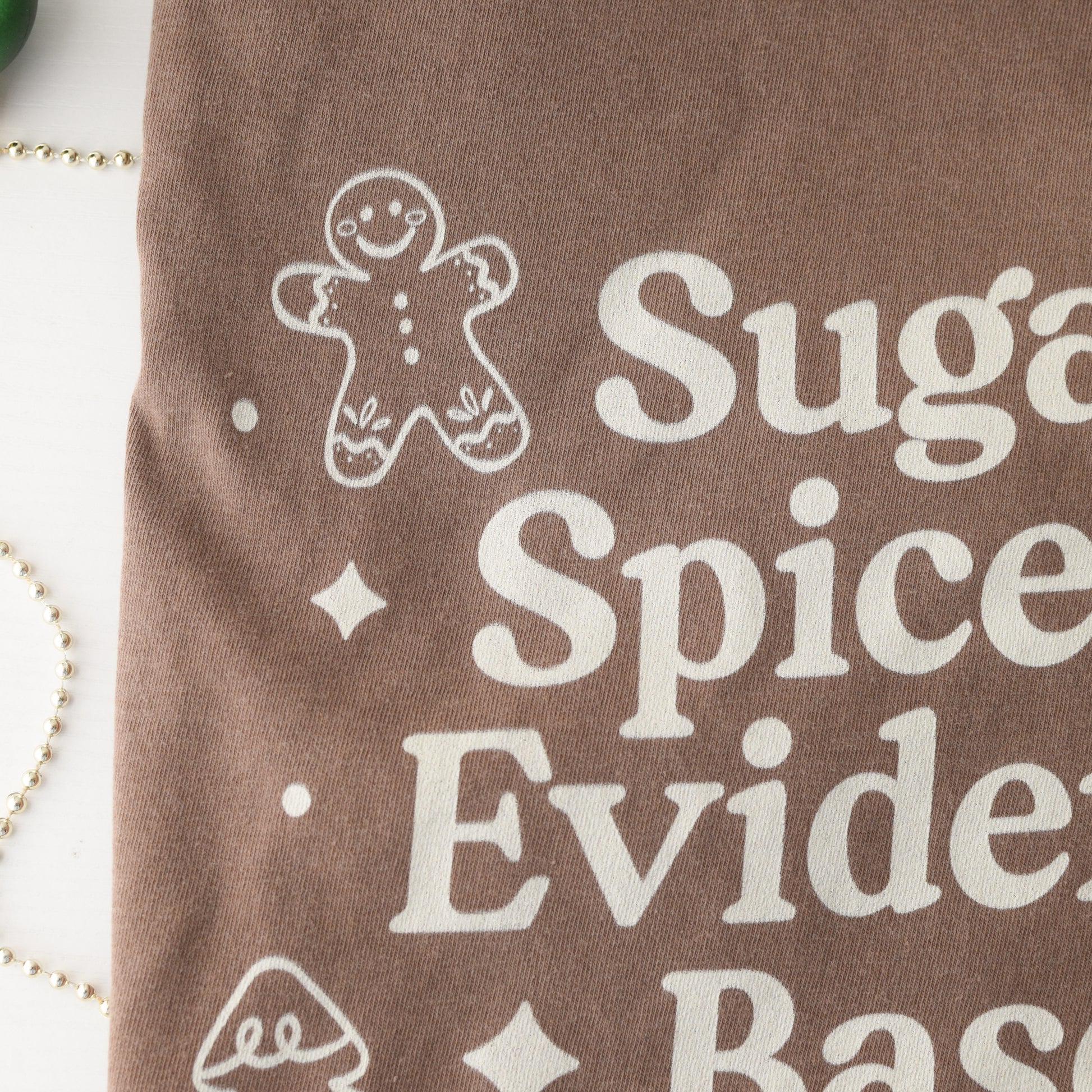 Brown fabric with white text and gingerbread man design on a white background