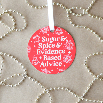 Red circular ornament with text 'Sugar & Spice & Evidence Based Advice' on a beige background with gold beads.