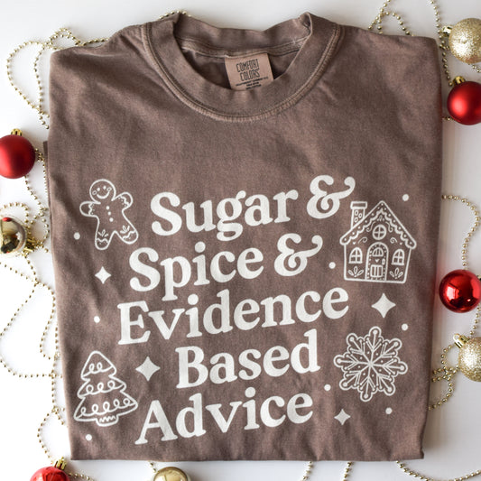 Brown t-shirt with white text and graphics on a decorative background with Christmas ornaments.