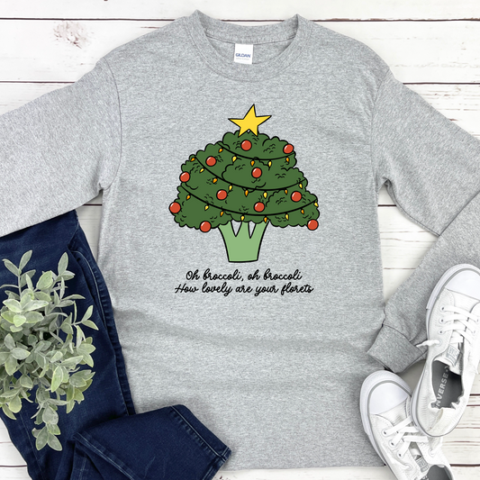 Sport gray long sleeve tee with a broccoli Christmas tree design and text on a wooden surface with jeans and sneakers.
