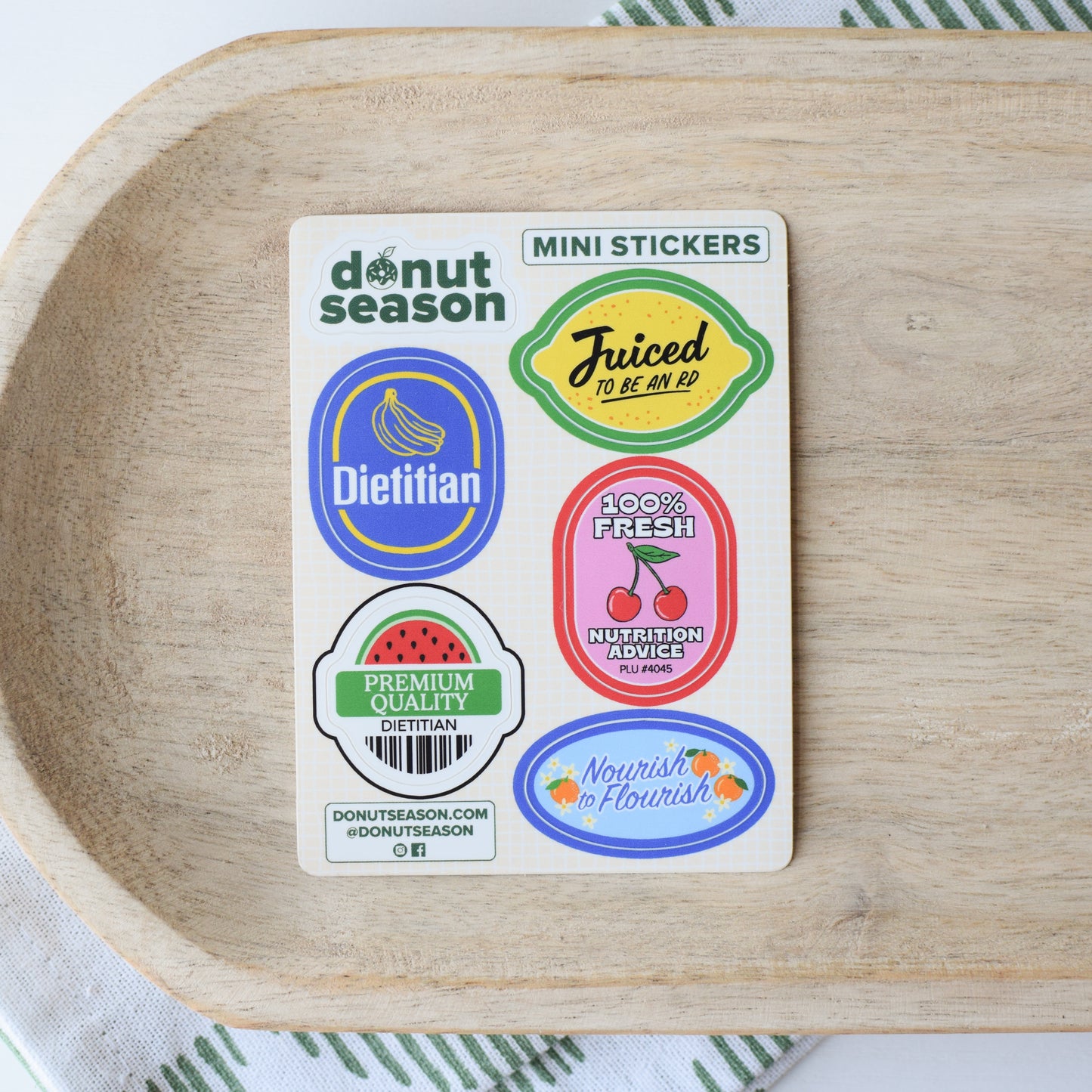 Sheet of mini produce stickers for dietitians from Donut Season on a wooden tray